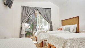 A hotel room with two beds, a wooden headboard, and a view of the outdoors. - Aaki Hotel (León)