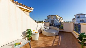 A rooftop terrace with a wicker sofa, a small table with books, and potted plants. - 3 bedroom amazing home in Orihuela Costa (Orihuela Costa)