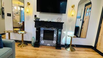 TV connectée, cheminée, livres, écrans d'ordinateur