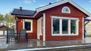 A red wooden cabin with large windows and a covered deck. - 2 bedroom stunning home in Mönsterås (Mönsterås)