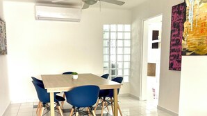 A dining area with a checkered floor, a ceiling fan, and a window with blinds.