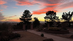 A residential area with a landscaped garden, a stone pathway, and a view of the sky during sunset. - Spacious Getaway: Patio, Pool, Hot Tub, Game Room (Apple Valley)