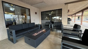A modern outdoor seating area with a sofa, chairs, and a fire pit. - Spacious Getaway: Patio, Pool, Hot Tub, Game Room (Apple Valley)