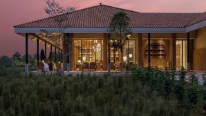 Une maison moderne dotée d’un patio couvert, de grandes fenêtres et d’une cheminée.