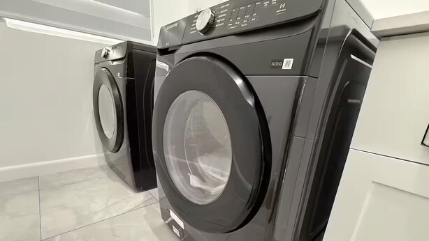 A modern laundry room with two front-loading washing machines.