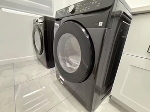 A modern laundry room with two front-loading washing machines.