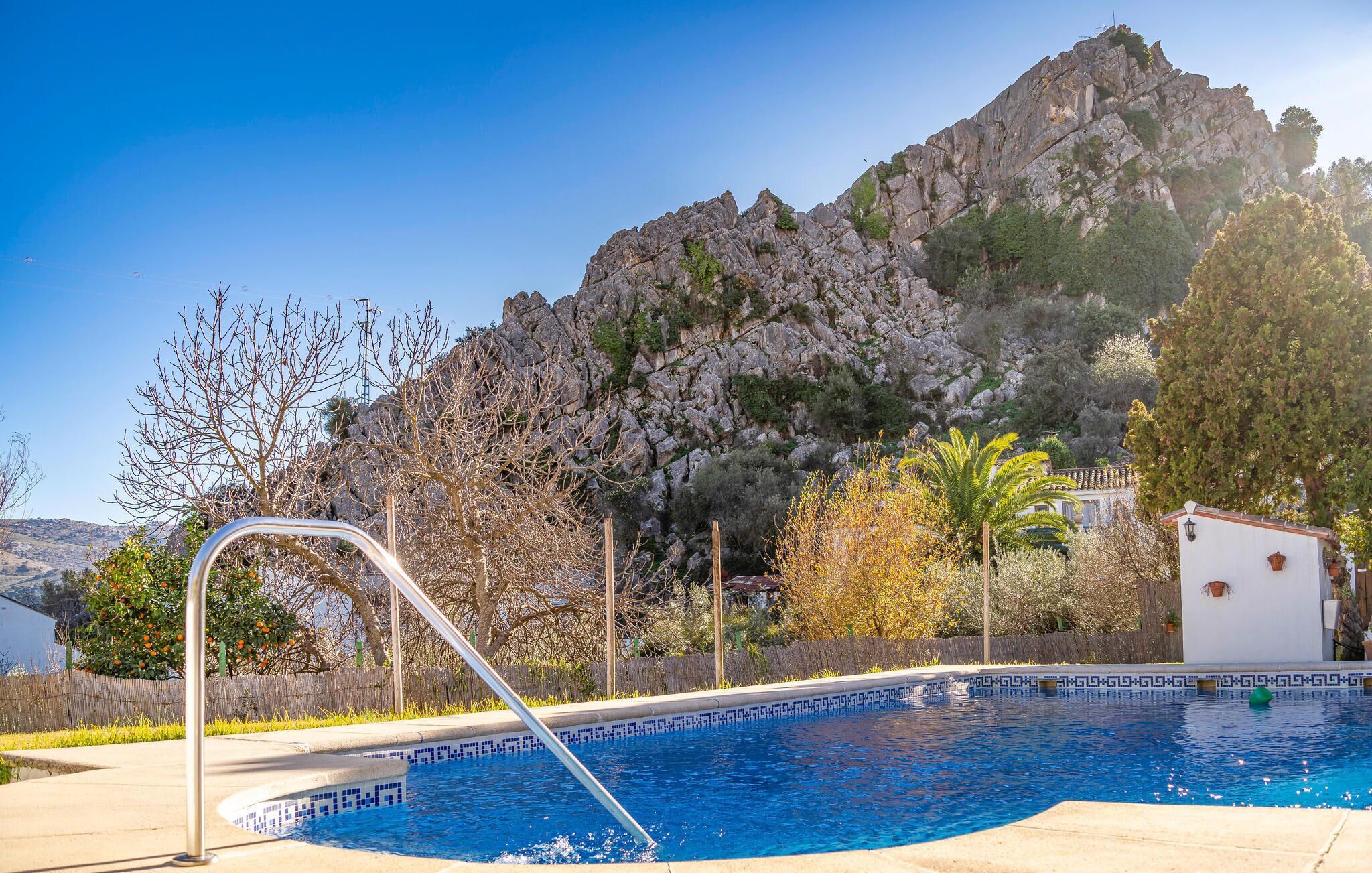 A swimming pool with a view of a rocky mountain and trees.