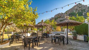 An outdoor patio with tables and chairs, thatched umbrellas, and string lights. - 2 bedroom stunning home in Montejaque (Montejaque)