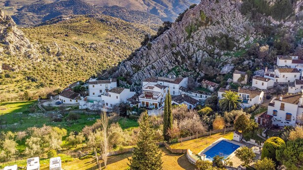 A hillside village with white buildings, a swimming pool, and a mountainous backdrop. - 2 bedroom stunning home in Montejaque (Montejaque)