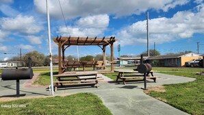 A park with picnic tables, a wooden pergola, and a barbecue grill. - Gulfway Motel By OYO Near Airport I 37 (Corpus Christi)