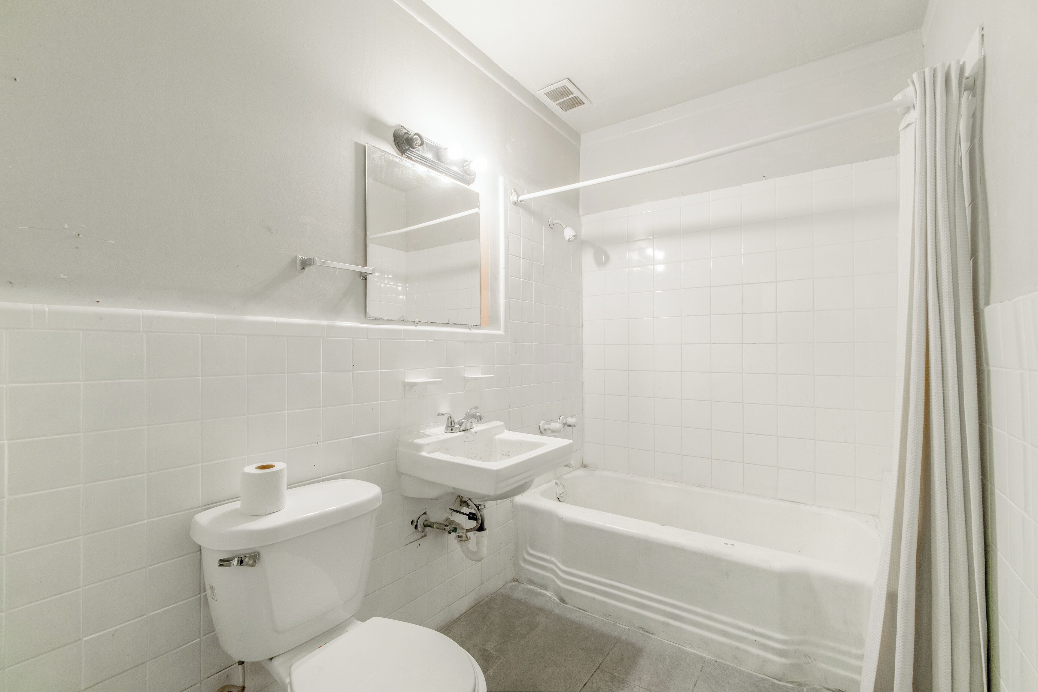 A bathroom with a toilet, sink, and bathtub.