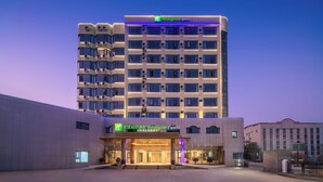 A Holiday Inn Express hotel with a modern facade, multiple air conditioning units, and a well-lit entrance. - Holiday Inn Express Longyan Liancheng by IHG (Longyan)