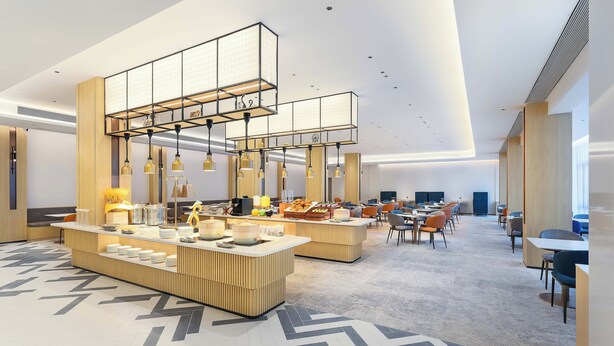 A modern hotel lobby with a central reception desk, multiple seating areas, and a high ceiling with recessed lighting. - Holiday Inn Express Longyan Liancheng by IHG (Longyan)