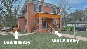 A two-story brick house with a front porch, two entries labeled 'Unit A Entry' and 'Unit B Entry', and a mailbox.