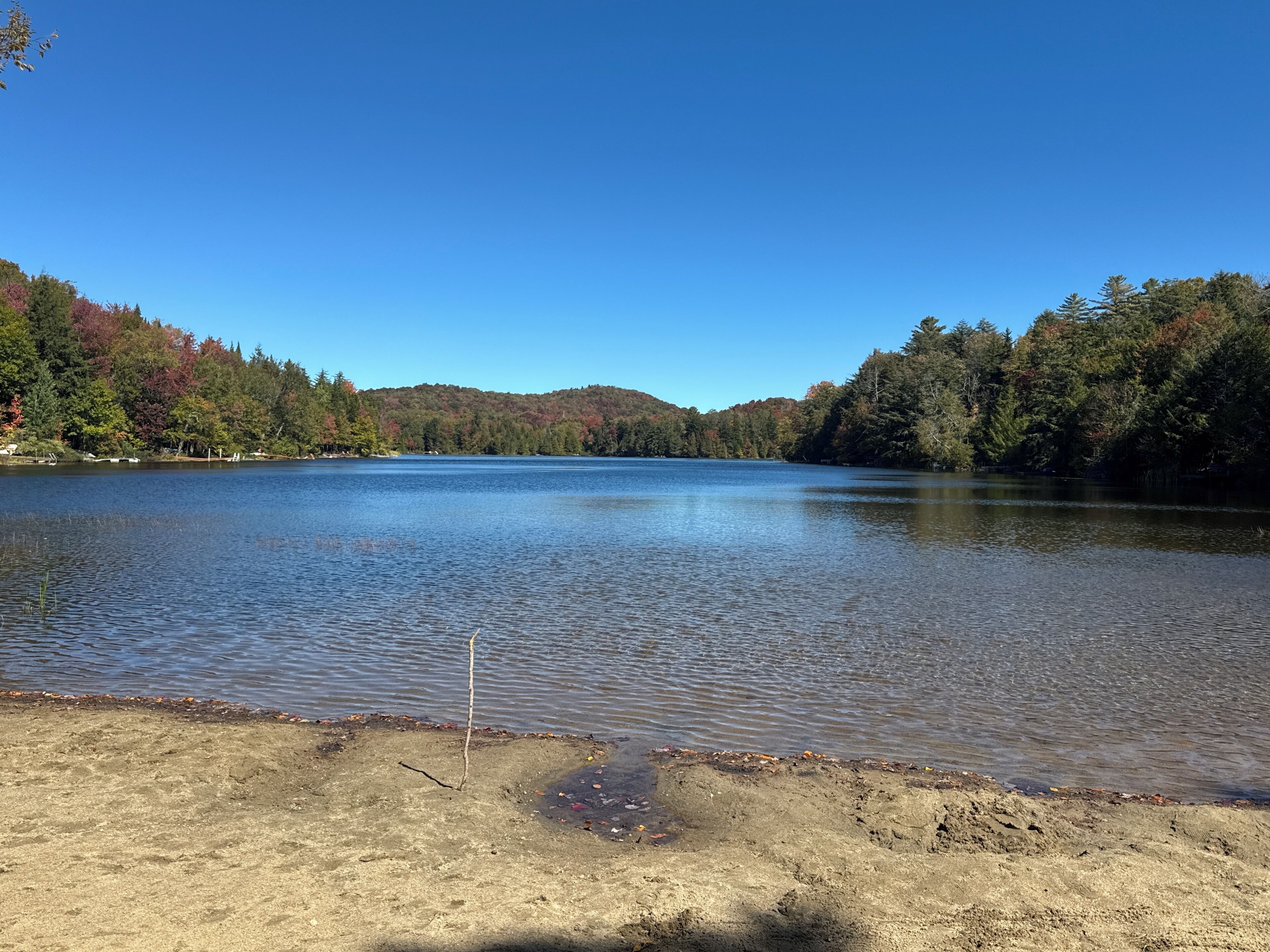 A calm lake surrounded by forested hills.