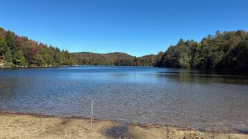 A calm lake surrounded by forested hills.
