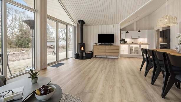 Un intérieur moderne avec un grand espace ouvert, une cheminée, un coin repas et une cuisine.