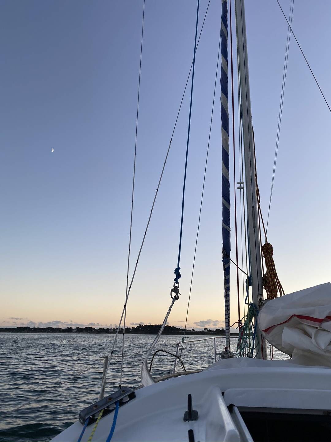 Eine Segelyacht mit freiem Blick auf das Wasser und einer fernen Küste.