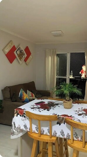 Relax in this inviting living space with a sofa, dining table, and potted plant.
