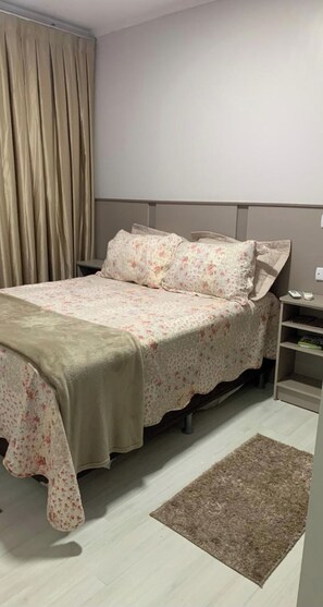 Relax in a serene bedroom with a comfortable bed, neutral headboard, and a cozy nightstand.