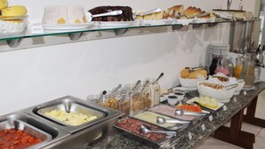 A buffet with various food items and utensils. - Brisa Pousada (Gramado)