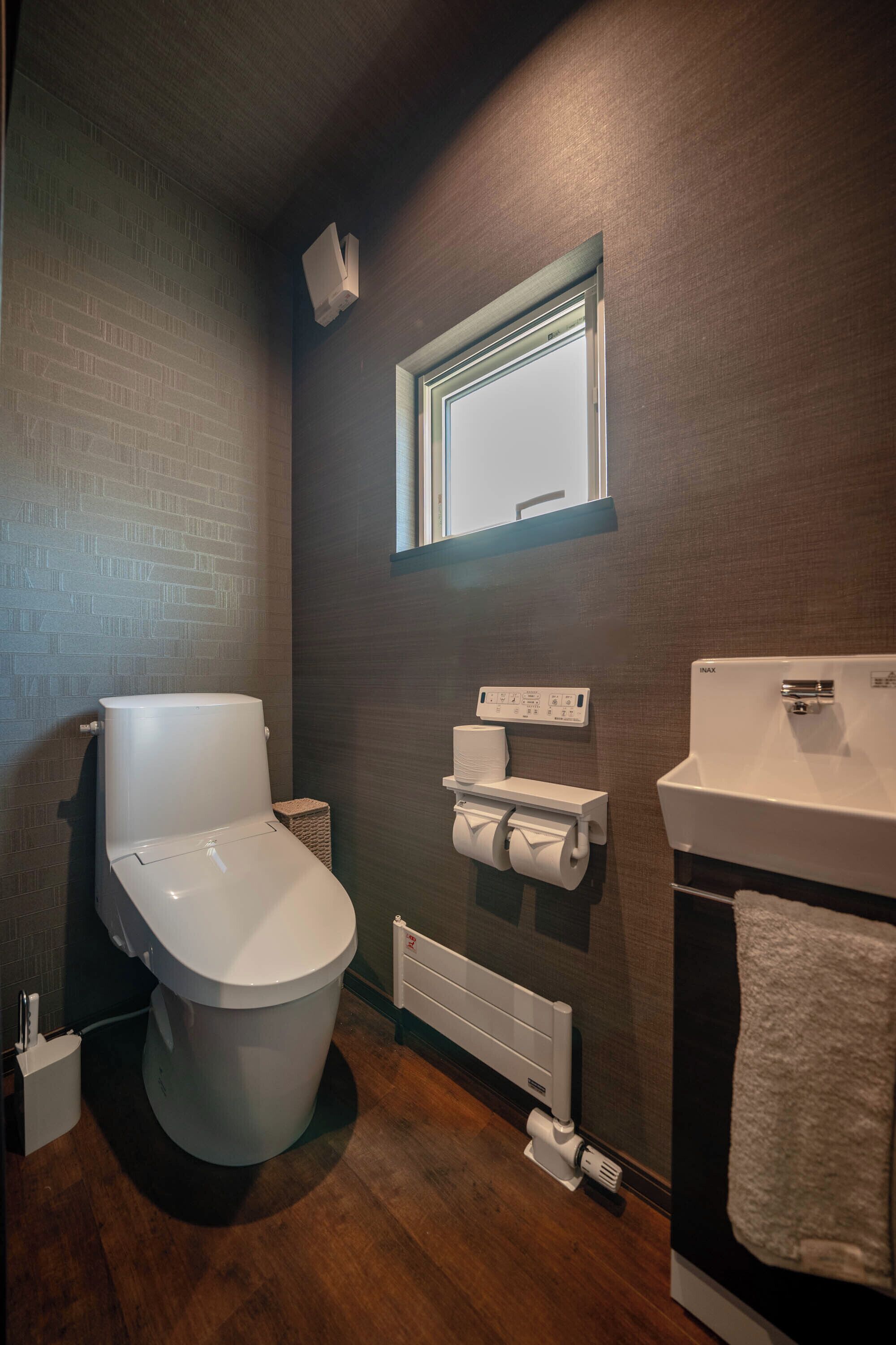 Un baño moderno con inodoro, bidé, toallero y ventana.