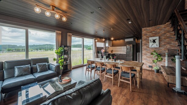 A spacious living area with a modern kitchen, large windows, and a wooden ceiling. - THE HORIZON RESIDENCE (Makubetsu)