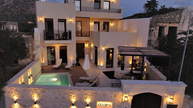 A modern two-story building with a swimming pool, outdoor seating, and a sign reading "Doder's Residence".