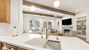 A modern kitchen with a large island, built-in appliances, and a fireplace. - (L75) Newly Renovated Single Story Townhome with Gorgeous Views, sleeps 8 (La Quinta)
