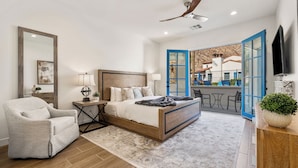 A bedroom with a bed, a chair, a desk, and a TV. - (L75) Newly Renovated Single Story Townhome with Gorgeous Views, sleeps 8 (La Quinta)