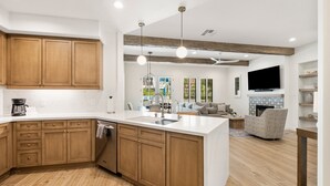 A modern kitchen with wooden cabinets, a large island, and a built-in oven. - (L75) Newly Renovated Single Story Townhome with Gorgeous Views, sleeps 8 (La Quinta)