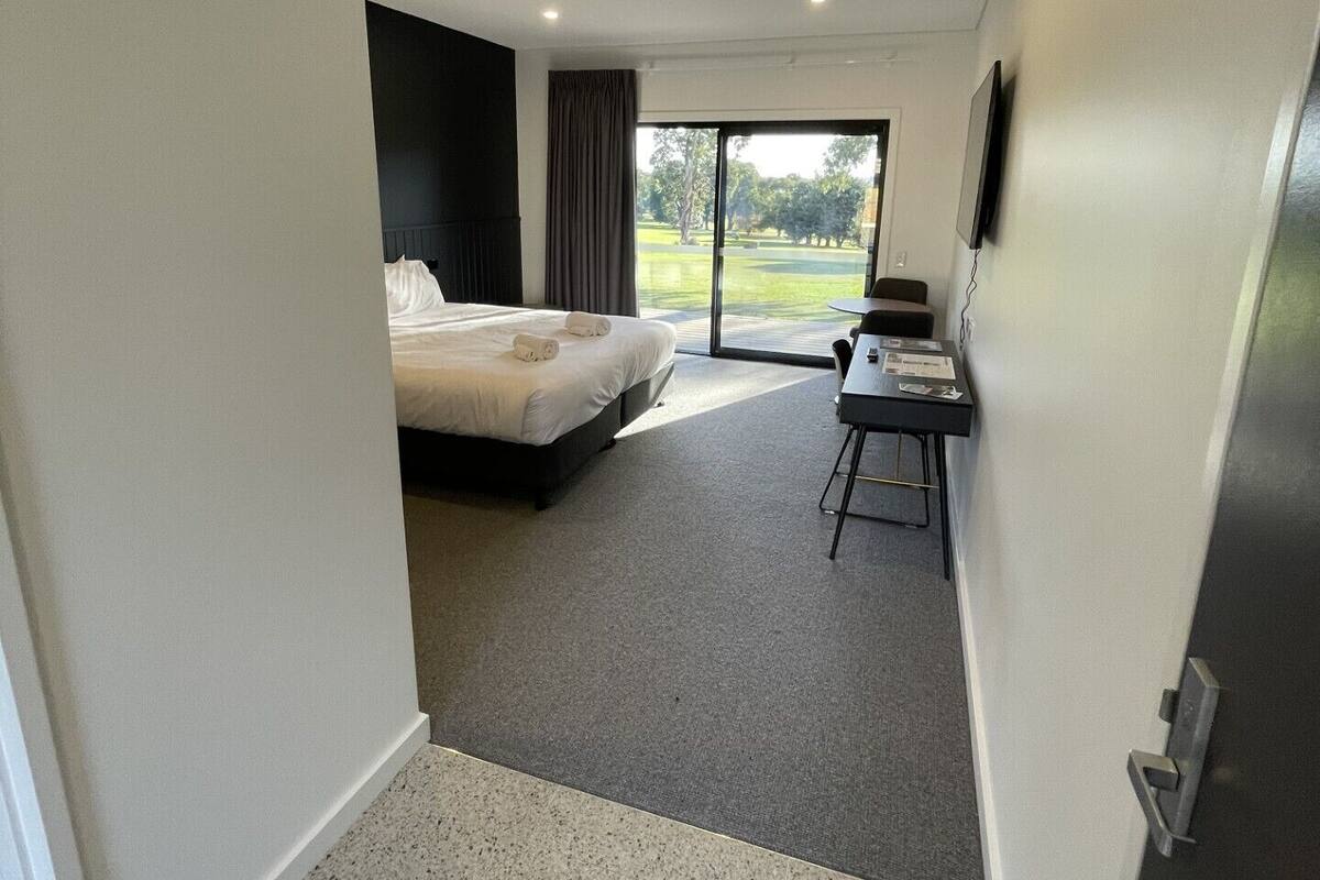 Une chambre d’hôtel avec un lit, un bureau et une vue sur l’extérieur.