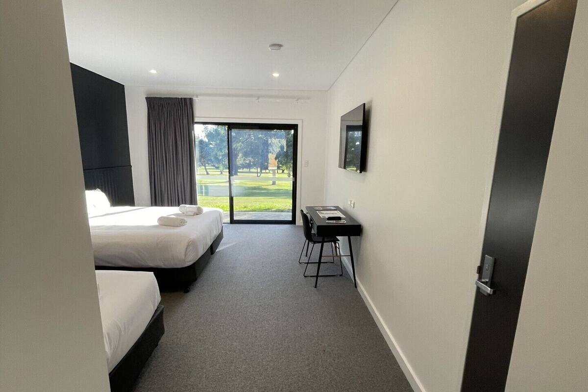 Une chambre d’hôtel avec un lit, un bureau et une télévision.