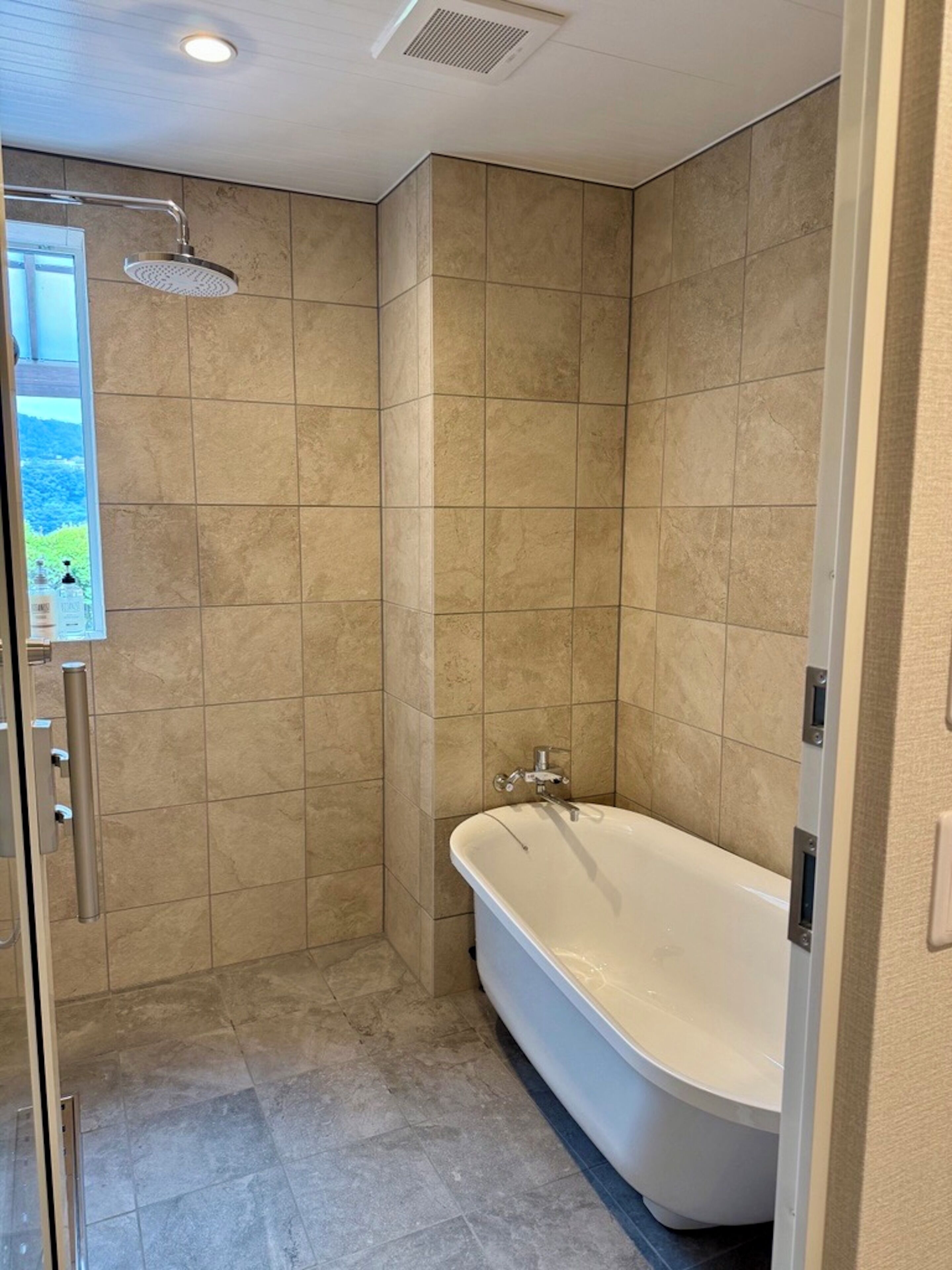 A bathroom with a shower, a bathtub, and a toilet.