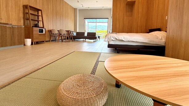 A modern room with a bed, a dining table, a sofa, and a kitchen area. - nunobikionsen komoro (Komoro)
