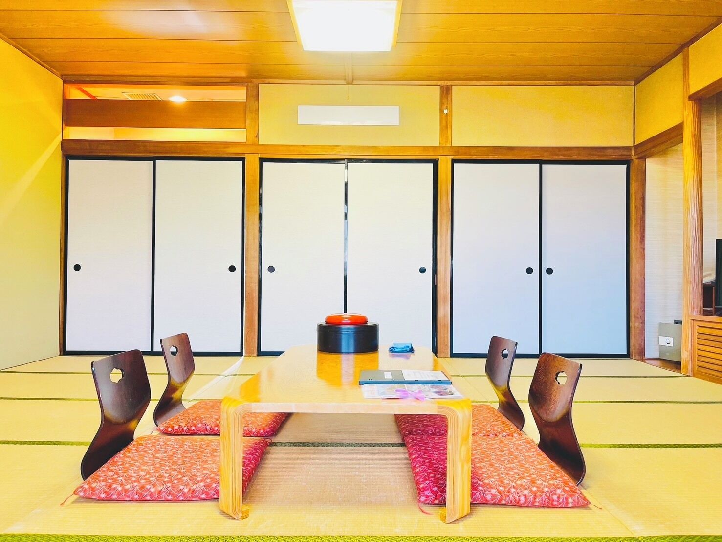 A traditional Japanese room with tatami flooring, a low table, and shoji screens.
