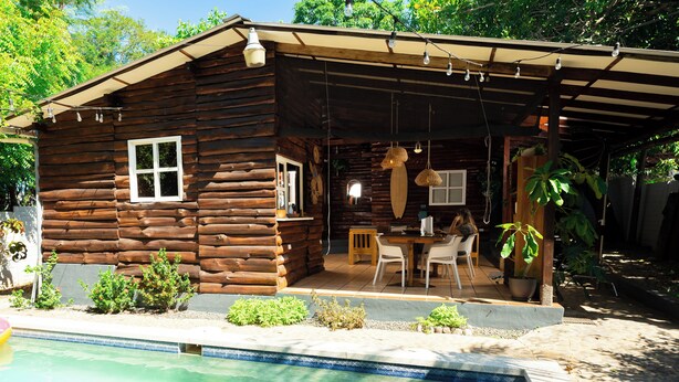 A wooden cabin with a pool, outdoor seating, and string lights. - Charming 3-bedroom beach cabin with Starlink WiFi, AC in enchanting Tamanique (Tamanique)