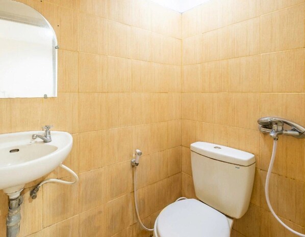 A small bathroom with a sink, toilet, and shower. - Rehat at Hotel Patradissa Stasiun Bandung (Bandung)