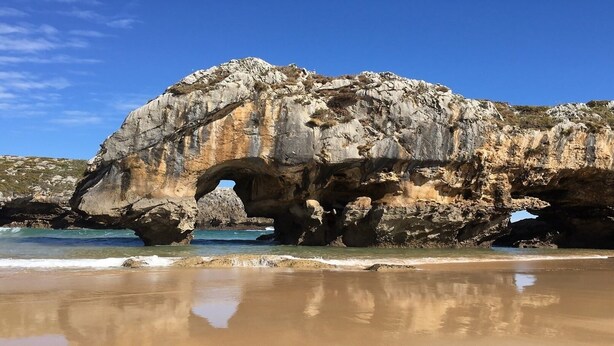 A natural rock formation with a large arch over the beach. - El Angel Vacation Home (Piñeres De Pria)