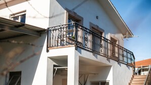 A two-story building with a balcony, a staircase, and a window. - El Angel Vacation Home (Piñeres De Pria)