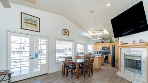 A modern kitchen with wooden cabinets, a built-in microwave, and a large TV mounted on the wall. - Oceans 11, Canal Front Family Fun, 60-FT Dock (Parker)