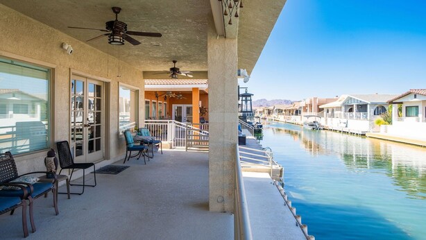 A covered outdoor area with seating and a view of a canal. - Oceans 11, Canal Front Family Fun, 60-FT Dock (Parker)