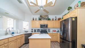 A modern kitchen with wooden cabinets, a central island, stainless steel appliances, and a ceiling fan. - Oceans 11, Canal Front Family Fun, 60-FT Dock (Parker)