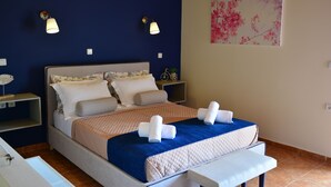 Un dormitorio con cama, mesitas de noche, una lámpara de pared y un cuadro.