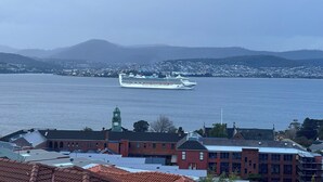 A cruise ship in a harbor with buildings and hills in the background. - Lipscombe Escape panoramic views luxury and space (HOBART)