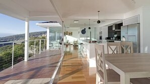 A modern kitchen with white cabinetry and a large island. - Lipscombe Escape panoramic views luxury and space (HOBART)