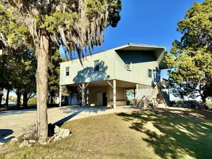 A two-story building with a covered porch and a staircase leading to the second floor. - Panoramic Water Views, Lg Screened SunPorch, Sleeps 6, 1DogOK (Citrus County)