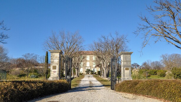 A pathway leading to a building with a classical facade, flanked by two stone pillars. - Awesome home in Saint-Laurent-du-Verdo (Saint-Laurent-du-Verdo)