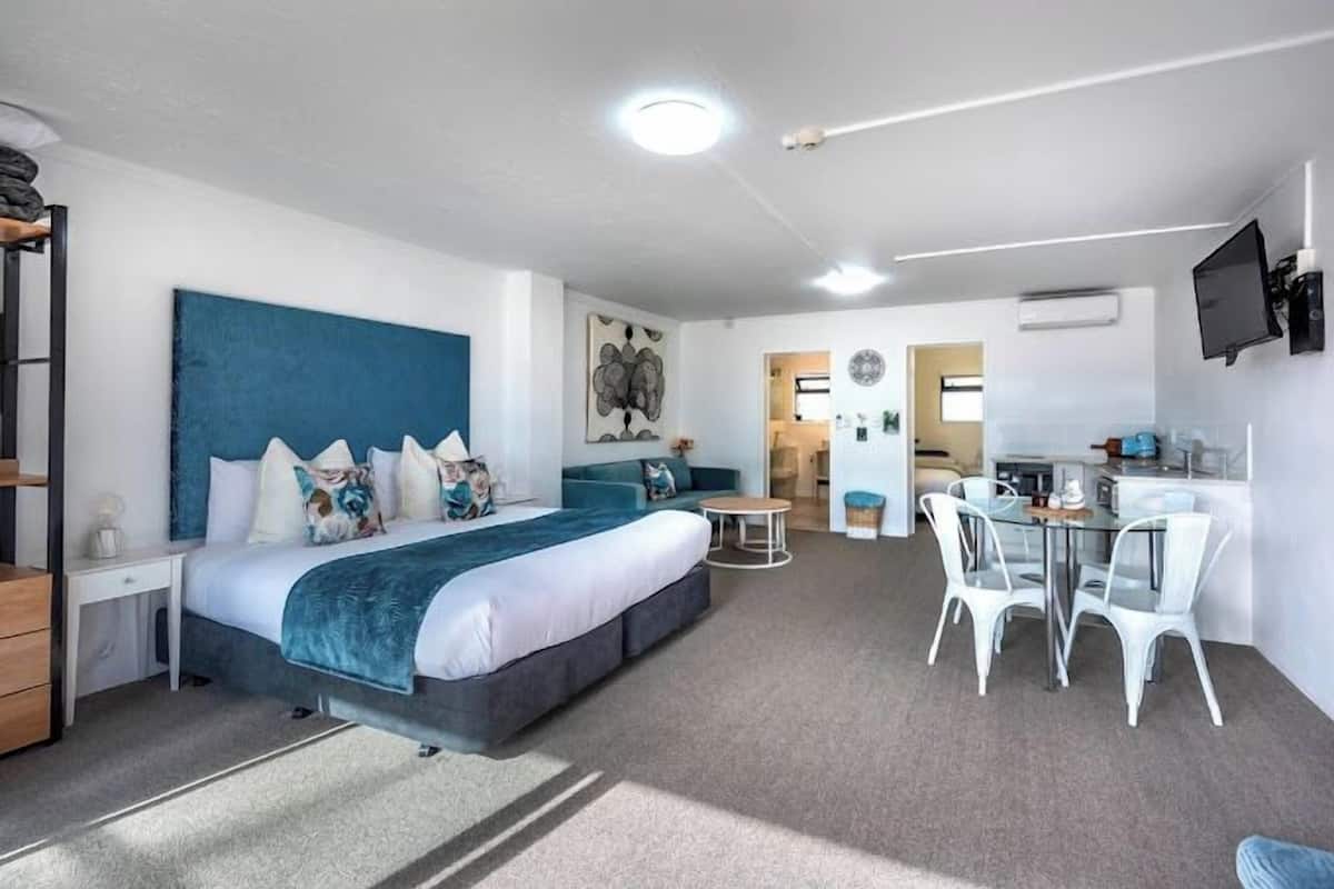Ein modernes Hotelzimmer mit einem großen Bett, einem Schreibtisch und einer Sitzecke.