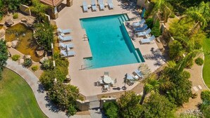 An aerial view of a resort with a central swimming pool, lounge chairs, and palm trees. - Scottsdal:  Pool , 2BR/2BTH - Elegant! (Scottsdale)
